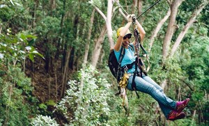 woman ziplining in hawaii and sticking her tongue out