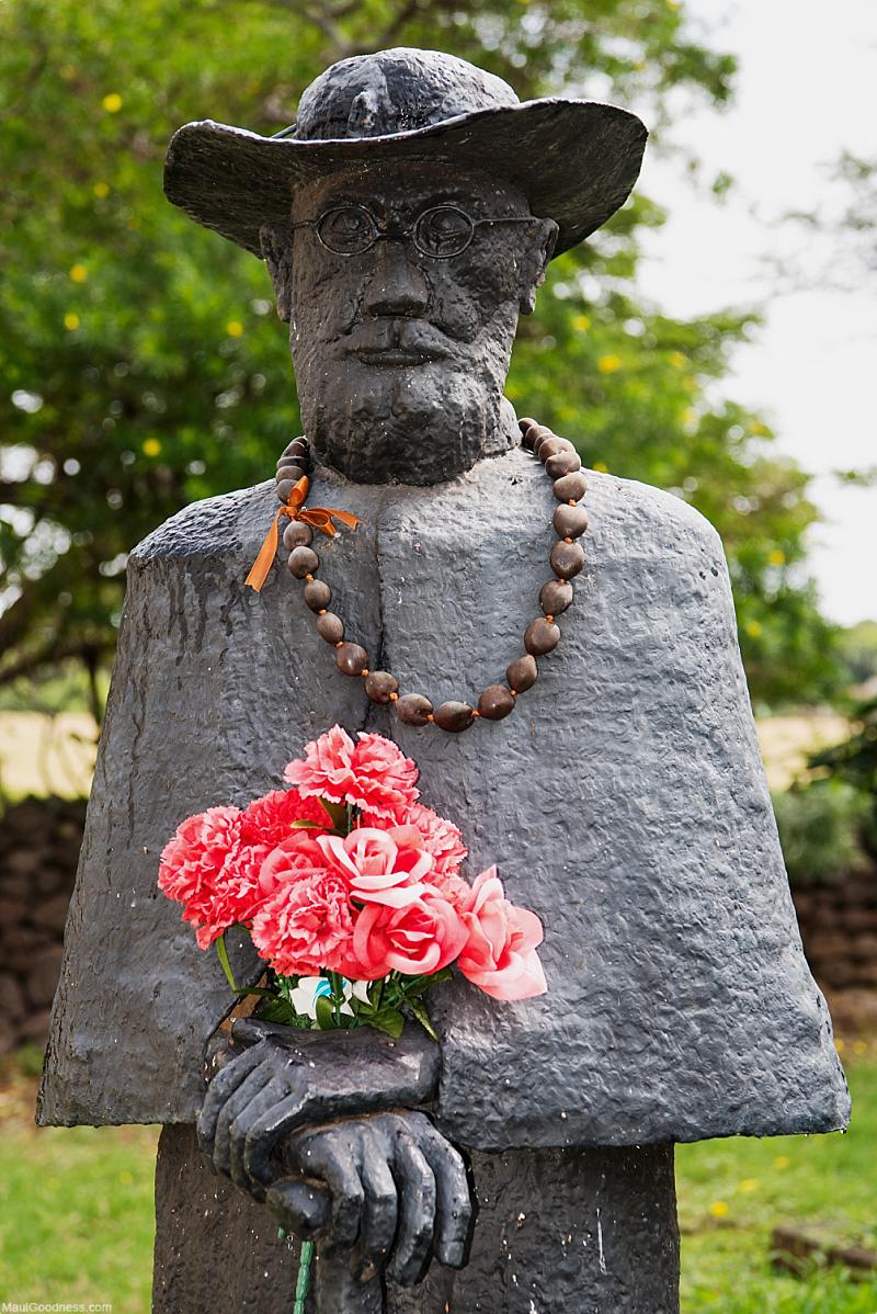 Father Damien statue wearing a lei and holding flowers