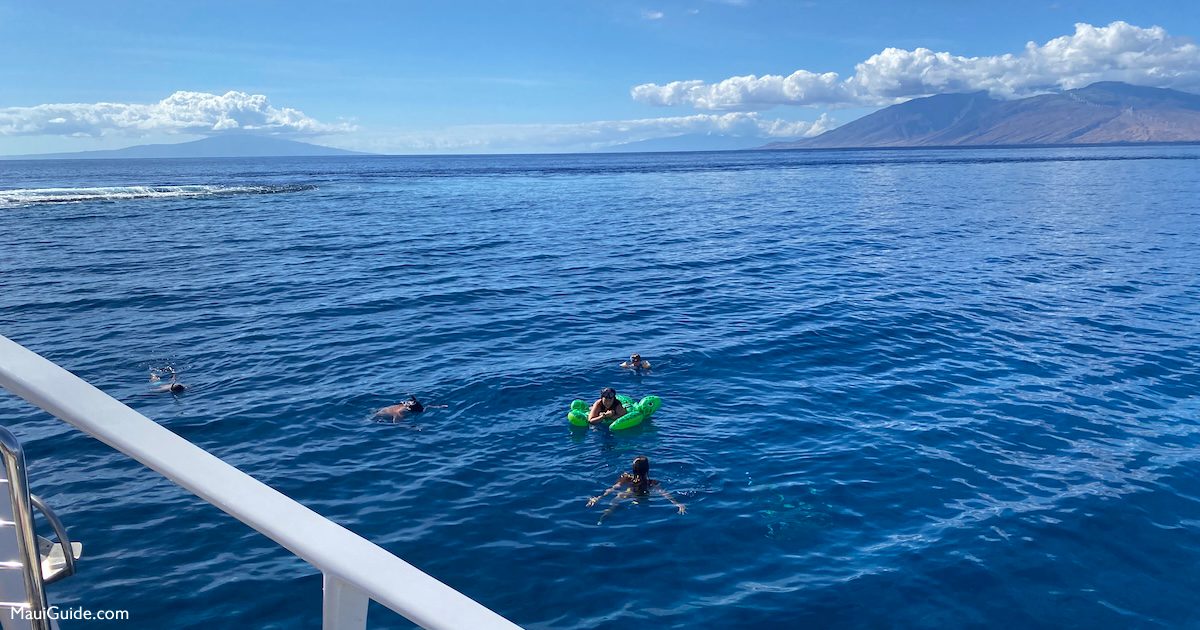 Snorkelers beside a Trilogy boat off Maui